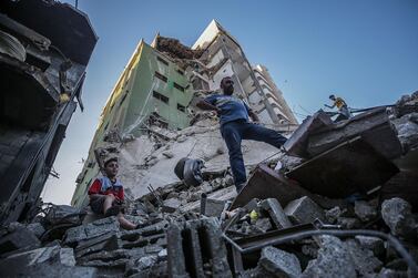 epa09213823 Palestinians inspect the rubble of their destroyed house after israeli airstrikes, in Gaza City, 19 May 2021. Clashes erupted 06 May over the forced eviction of six Palestinian families from their homes in Sheikh Jarrah neighborhood in favor of Jewish families who claimed they used to live in the houses before fleeing in the 1948 war that led to the creation of Israel. In response to days of violent confrontations between Israeli security forces and Palestinians in Jerusalem, various Palestinian militants factions in Gaza launched rocket attacks since 10 May that killed at least 12 Israelis to date. The Palestinian health ministry said that at least 219 Palestinians, including 63 children, were killed in the retaliatory Israeli airstrikes. EPA/MOHAMMED SABER