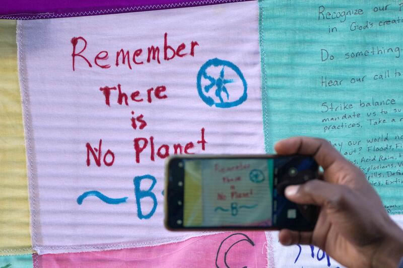 A person takes a picture of messages left on a fence at the Scottish Event Campus in Glasgow. PA