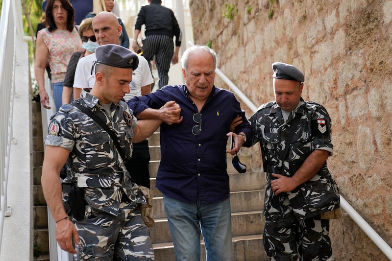 Lebanese policemen help a voter into a polling station in Beirut. AP
