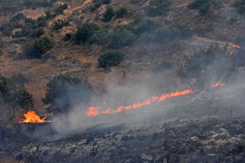 A handout picture released by the official Syrian Arab News Agency (SANA) shows fires on a hill in Ain Halaqim, in the western countryside of Syria's Hama governorate. AFP