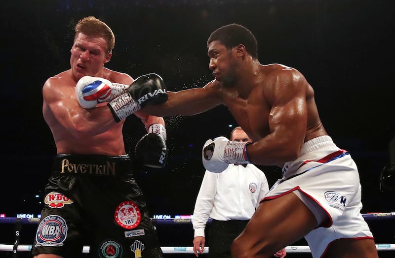 Britain's Anthony Joshua, right,  lands a blow on Alexander Povetkin on his way to retaining his WBA, IBF, and WBO heavyweight boxing titles, Saturday, Sept. 22, 2018, at Wembley Stadium in London. (Nick Potts/PA via AP)