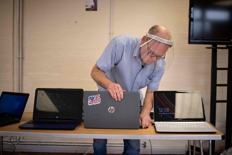 Damian Griffiths, director of Catbytes, a computer repair charity, checks and prepares donated computers for distribution at Ewart Community Hall in south London. AFP