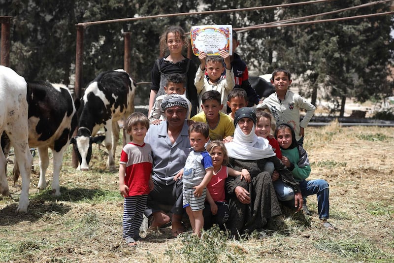 Syrian cattle farmer Saleh Farah, also known as 'Abu Ahmed', poses with his family at his farm in the village of Al Hayjana, in the Badia region. Badia was popular for grazing but Syria's decade-long civil war has turned it into a no-go zone.  AFP