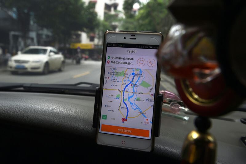 (FILES) This file picture taken on May 13, 2016 shows a taxi driver using the Didi Chuxing app while driving along a street in Guilin in China's southern Guangxi region. - China's transport ministry on August 26, 2018 slammed Didi Chuxing's safety lapses as the ride-hailing giant said it would suspend its Hitch service after the rape and murder of a passenger, the second such killing this year. (Photo by Greg Baker / AFP)