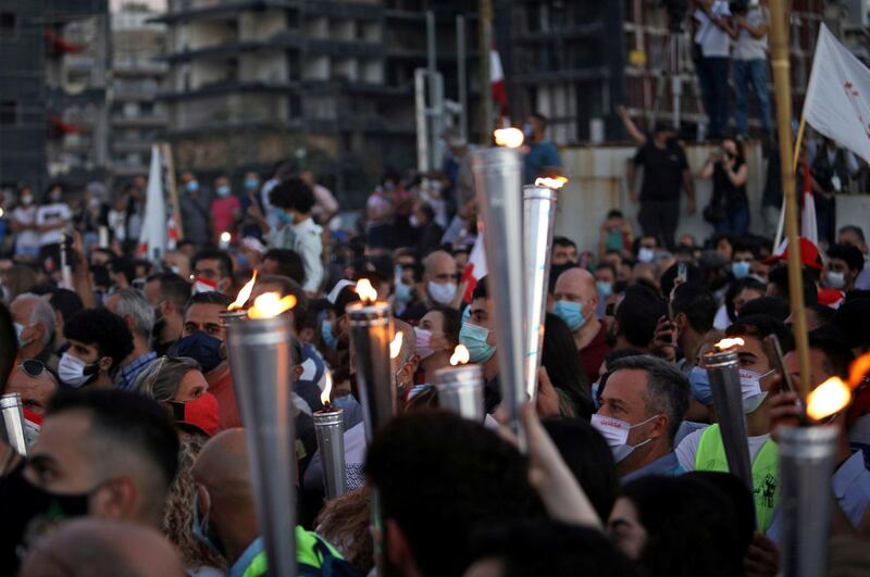 FILE PHOTO: People carry torches during a demonstration marking one year since the start of nation-wide protests near Beirut's port, Lebanon October 17, 2020. REUTERS/Emma Freiha/File Photo