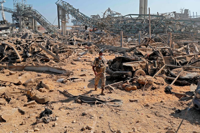 TOPSHOT - A Lebanese army soldier walks amidst the debris at Beirut port on August 7, 2020, three days after a massive blast there shook the Lebanese capital. The explosion of a huge pile of ammonium nitrate that had languished for years in a port warehouse served as shocking proof to many Lebanese of the rot at the core of their system, with seething anti-government protests erupting late Thursday near parliament. World leaders have joined the chorus of Lebanese in the country and abroad demanding an international probe into a blast that killed nearly 150 and wounded at least 5,000 people. At least 300,000 were left temporarily homeless, including nearly 80,000 children, the United Nations' child agency has said, warning that many have been separated from their families. / AFP / JOSEPH EID

