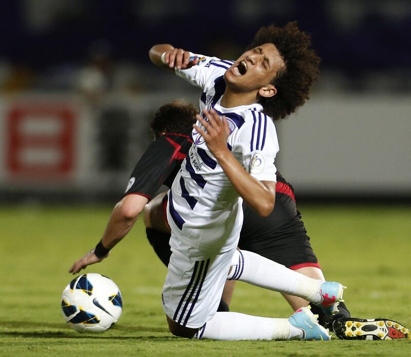 Omar Abdulrahman (front) of UAE's Al-Ain club vies for the ball against Nathan Otavio Ribeiro (L) of Qatar's Al-Rayyan club during their AFC Champions League football match in the eastern Emirati city of Al-Ain on April 3, 2013. AFP PHOTO /KARIM SAHIB
 *** Local Caption ***  832210-01-08.jpg