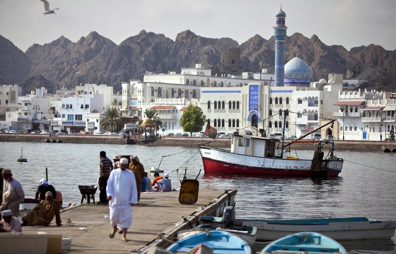 Backed by the white buildings that line the corniche of Mutrah district, fishermen and delivery staff work near the Mina Sultan Qaboos in downtown Muscat. Silvia Razgova / The National



