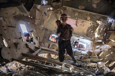 A boy stands inside an old tank in Qala-e-Naw, Badghis. Stefanie Glinski / The National