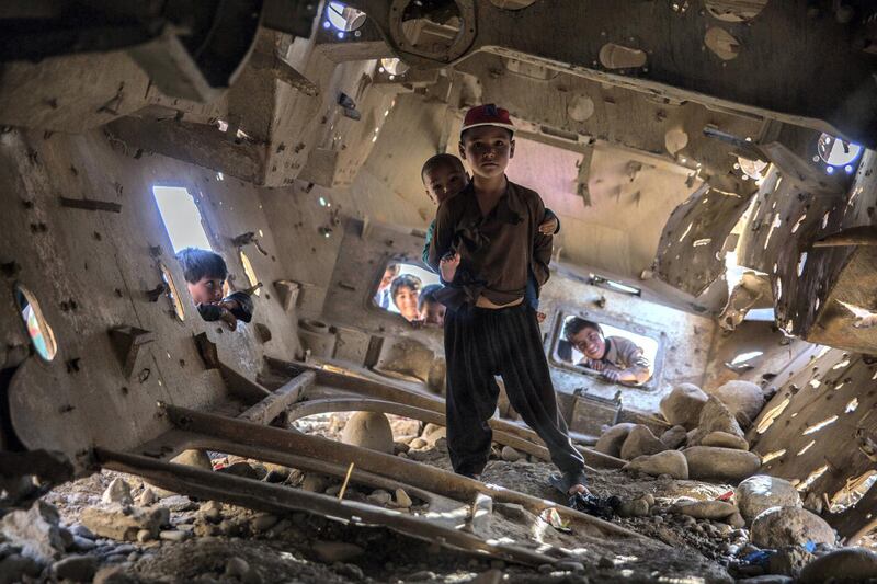 A boy stands inside an old tank in Qala-e-Naw, Badghis. 