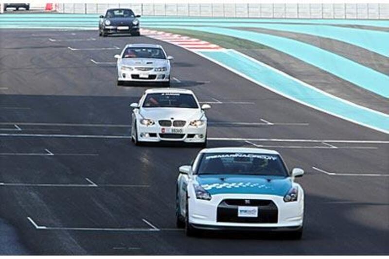 Members of the public are led around the Yas Marina Circuit yesterday after taking up the opportunity to drive their cars on the Formula 1 track.