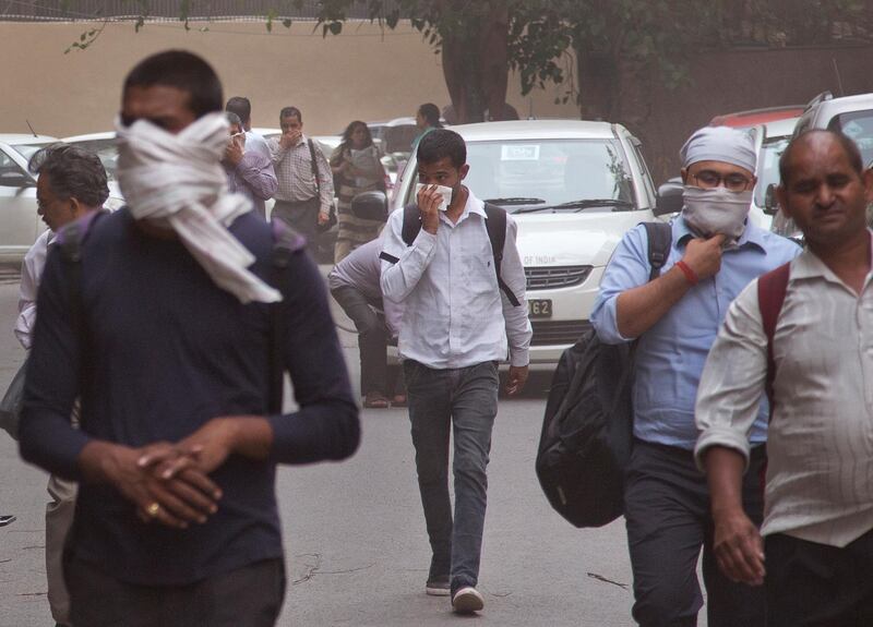 People cover their faces as a dust storm sweeps through New Delhi. Manish Swarup / AP Photo