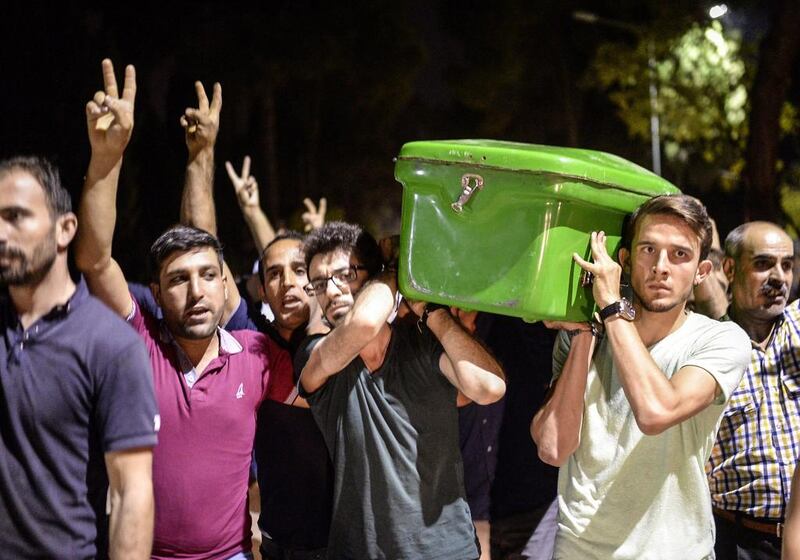 People carry a coffin of one of the victims of a suicide attack through the streets of Gaziantep, following the attack in which killed at least 31 in a southern Turkish town. Bulent Kilic / AFP 