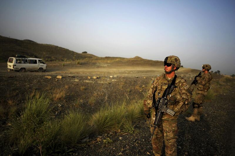 (FILES) In this file photo members of the 1st Platoon Comanche Company of the US Army stand at a checkpoint in the Combat Outpost Lakon in Buwri Tana District, Khost Province on August 9, 2012.    US President Joe Biden warned that a deadline to withdraw all American soldiers from Afghanistan by May 1, 2021 as part of a deal with the Taliban was possible but "tough." "Could happen, but it is tough," Biden said when asked in a TV interview broadcast Wednesdayon March 17, 2021. / AFP / Jose CABEZAS
