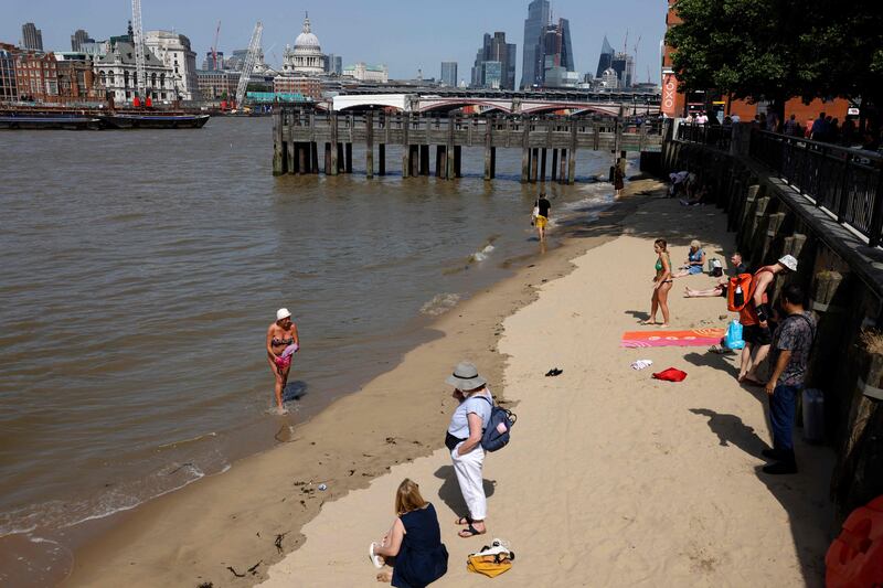 People cool off beside the River Thames. AFP