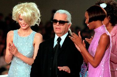 FILE - In this Monday Oct.14, 1996 file photo, Karl Lagerfeld is applauded by Claudia Schiffer, left, and Naomi Campbell at the end of the Chanel 1997 Spring-Summer ready-to-wear collection presented in Paris. Chanel's iconic couturier, Karl Lagerfeld, whose accomplished designs as well as trademark white ponytail, high starched collars and dark enigmatic glasses dominated high fashion for the last 50 years, has died. He was around 85 years old. (AP Photo/Remy de la Mauviniere, File)