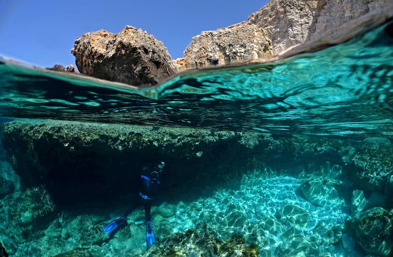 Cypriot marine ecologist Louis Hadjioannou takes pictures of coral as he monitors the effects of climate change in the crystal clear waters off the island's south-eastern shore. AFP