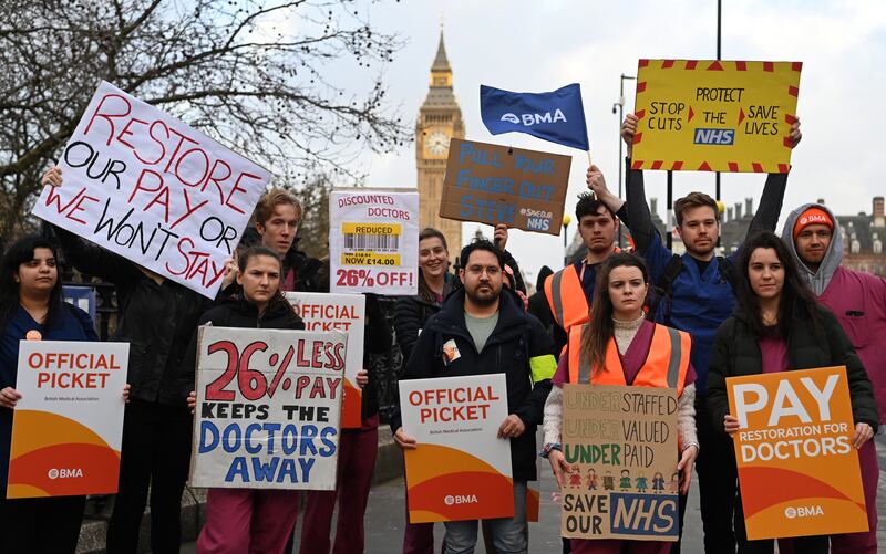 Junior doctors hold placards at a picket while on strike outside StThomas' Hospital in London. EPA