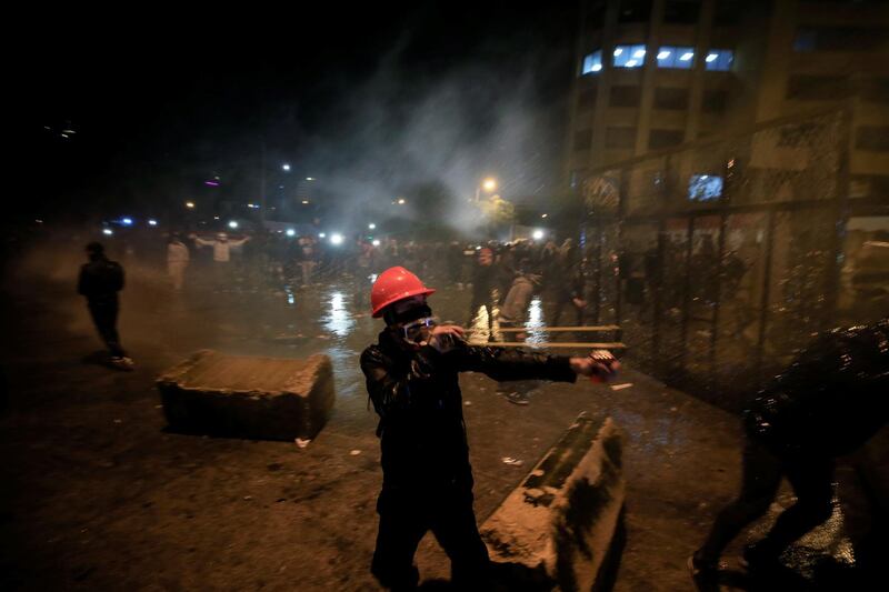 A demonstrator uses a slingshot to throw a stone during a protest against the newly formed government. Reuters