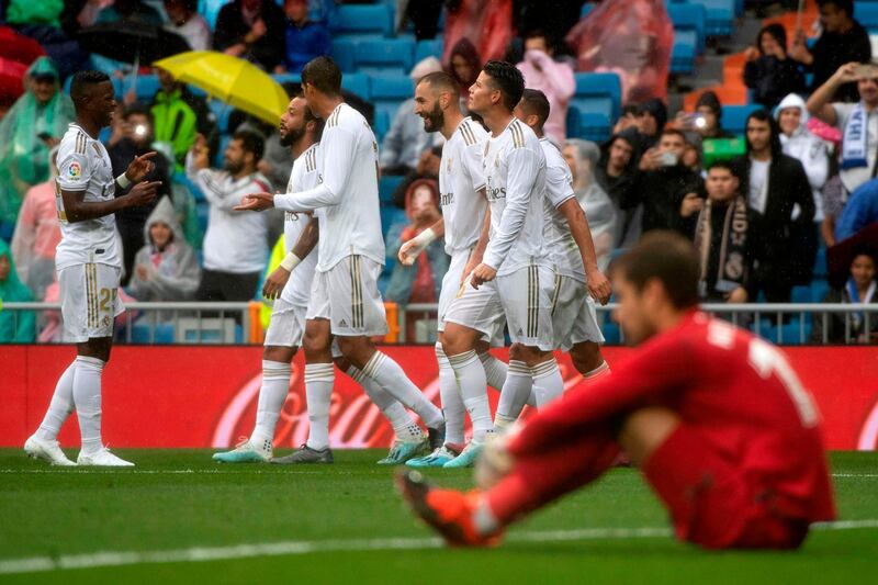 Real Madrid's French forward Karim Benzema celebrates with teammates after scoring his and Madrid's second goal on 31 minutes. AFP