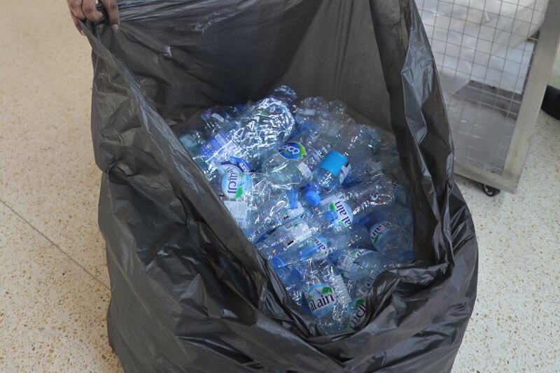 Workers collect plastic bottles for recycling. Nilanjana Gupta / The National