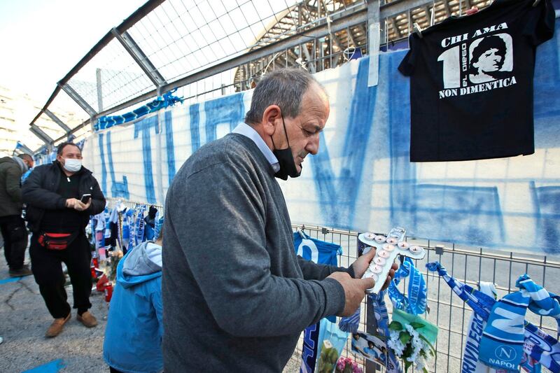 A man lights candles as fans gather outside the San Paolo stadium to commemorate Diego Maradona. AP Photo