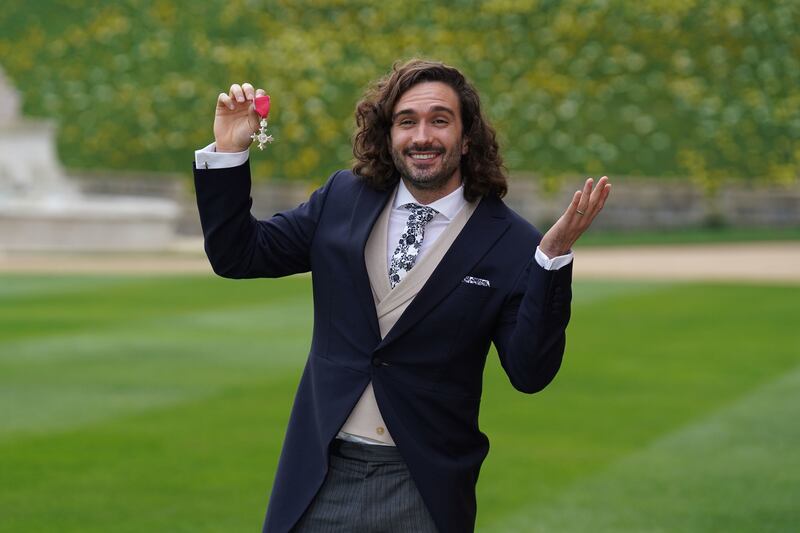 YouTube fitness coach Joe Wicks poses with his MBE at Windsor Castle on Wednesday. Wicks' online workouts became a staple of many people's days during the 2020 coronavirus lockdown, with a world record 950,000 viewers tuning in to his livestream in March 2020. Getty Images