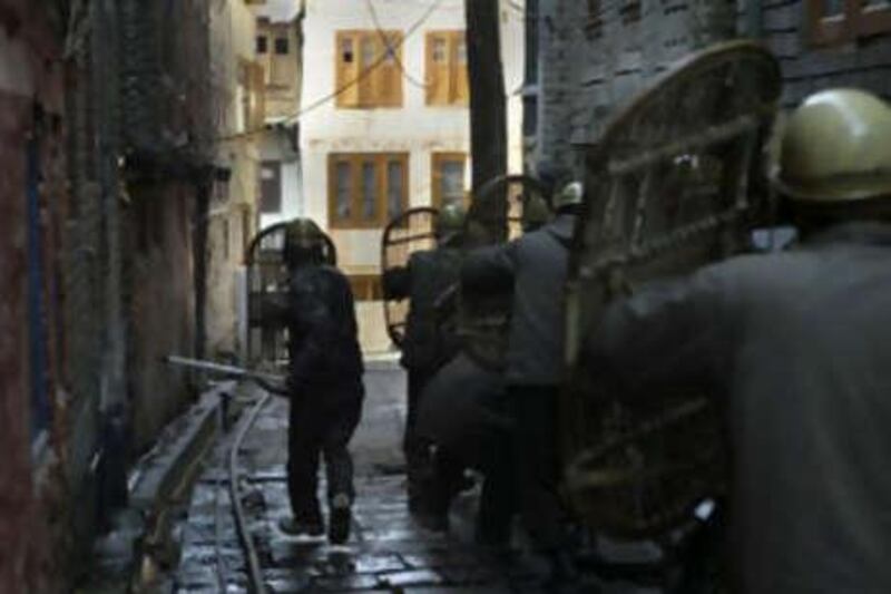 Indian policemen take position as they chase away Kashmiri Muslim protesters during an anti-election protest.