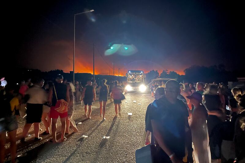 Tourists wait for buses at Gennadi Beach on the Island of Rhodes. AP