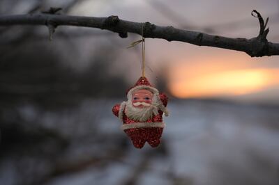 A Santa Claus Christmas decoration hangs from a tree branch outside a bunker at a frontline position outside Popasna, the Luhansk region, in eastern Ukraine, just after the war began in February. AP Photo