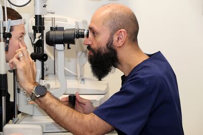 Daniel Crown, Optometrist examine the patient at the Moorfields eye hospital in Abu Dhabi. Pawan Singh / The National