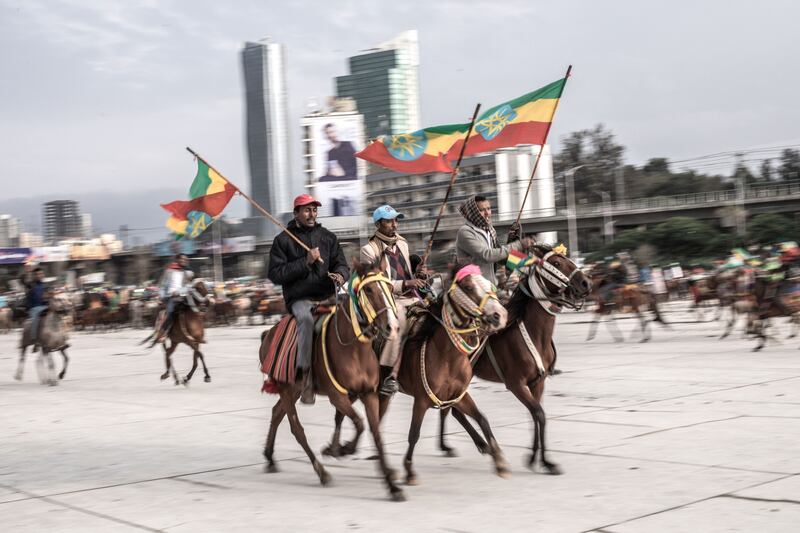 People on horseback wave flags at the rally.