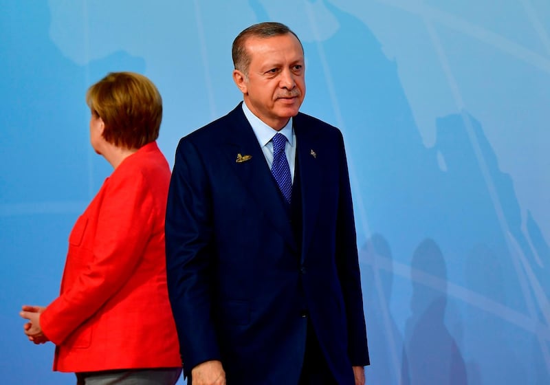 (FILES) In this file photo taken on July 7, 2017 German Chancellor Angela Merkel welcomes Turkey's President Recep Tayyip Erdogan as he arrives to attend the G20 summit in Hamburg, northern Germany, on July 7, 2017. Germany's Angela Merkel hosts Turkish President Recep Tayyip Erdogan in Berlin on September 28, 2018 to try to repair badly frayed ties, a task complicated by planned anti-Erdogan protests and the chancellor's own domestic woes. / AFP / Tobias SCHWARZ
