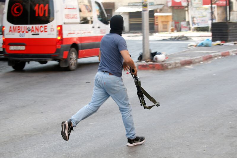 A Palestinian militant engages with the Israeli military. EPA