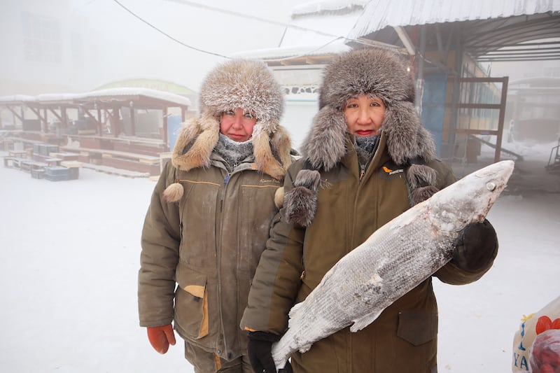 Fish vendors Marina Krivolutskaya and Marianna Ugai pose for a picture at an open-air market on a frosty day in Yakutsk, Russia, January 15, 2023.  Yakutsk, one of the Russia's north-most cities, is hit by an extreme cold snap as the air temperature on Sunday (January 15) plunged as low as minus 51 degrees Celsius (minus 59. 8 degrees Fahrenheit).  REUTERS / Roman Kutukov