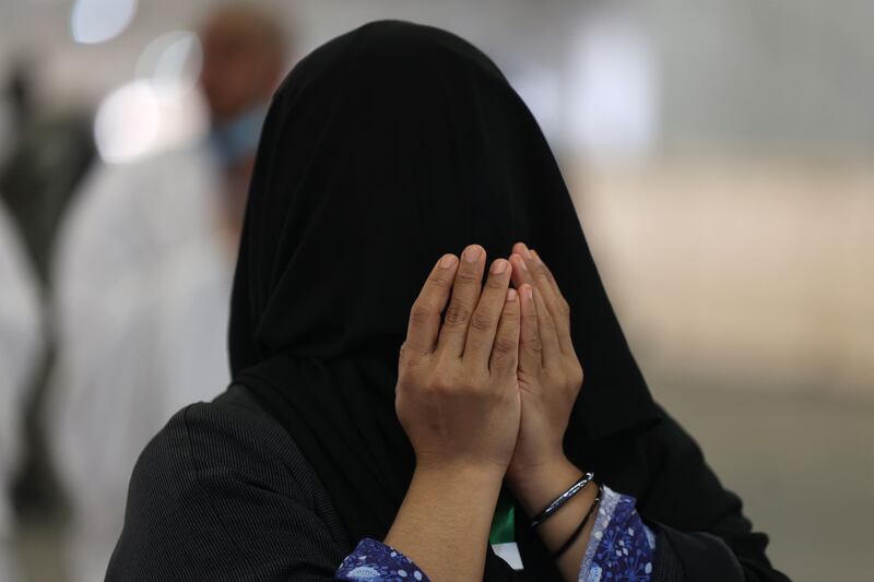 A Muslim worshipper prays as she arrives to cast pebbles during a symbolic stoning of the devil ritual.