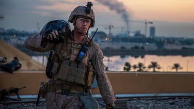 In this Saturday, Jan. 4, 2020, photo, released by the U.S. military, a U.S. Marine with 2nd Battalion, 7th Marines that is part of a quick reaction force, carries a sand bag during the reinforcement of the U.S. embassy compound in Baghdad, Iraq, Jan. 4, 2020. The blowback over the U.S. killing of a top Iranian general mounted Sunday, Jan. 5 as Iraq's Parliament called for the expulsion of American troops from the country â€” a move that could allow a resurgence of the Islamic State group. (U.S. Marine Corps photo by Sgt. Kyle C. Talbot via AP)