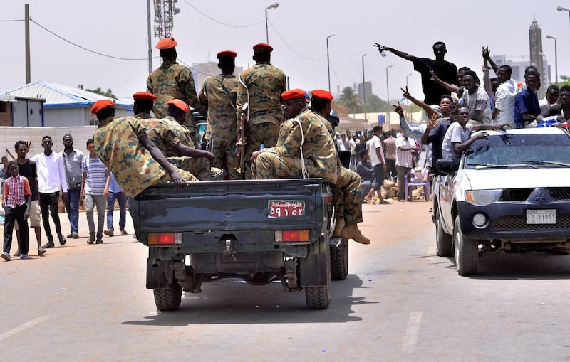 Sudanese demonstrators cheer as they drive towards a military vehicle, after Sudan's Defense Minister Awad Mohamed Ahmed Ibn Auf said that President Omar al-Bashir had been detained "in a safe place" and that a military council would run the country for a two-year transitional period, near Defence Ministry in Khartoum, Sudan April 11, 2019. REUTERS/Stringer