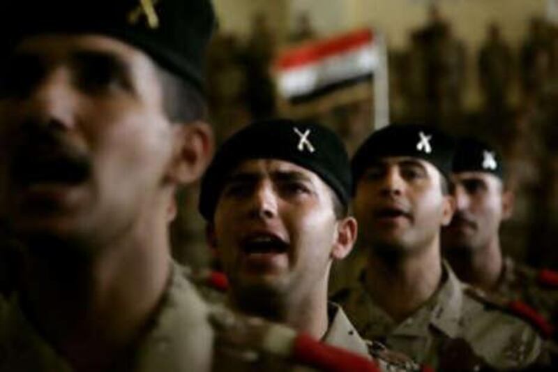Iraq's new lieutenants stand at attention during their graduation ceremony from officer training yesterday.