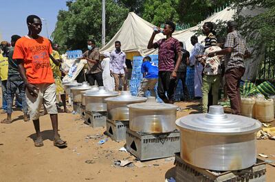 Sudanese protesters prepare food outside the presidential palace on the second day of a sit-in demanding the dismissal of civilian-led government. AFP