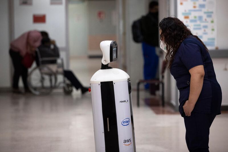 A healthcare worker communicates with a fellow doctors via Laluchy Robotina, a robot designed to aid in the mental health of patients infected with the new coronavirus, at 20 de November National Medical Centre in Mexico City. AP Photo