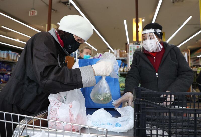 A shopper and cashier wear protective equipment at the checkout station at Pat's Farms grocery store in Merrick, New York. AFP