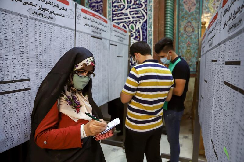 Iranians check the names of candidates during presidential elections at a polling station in Tehran, Iran. Reuters