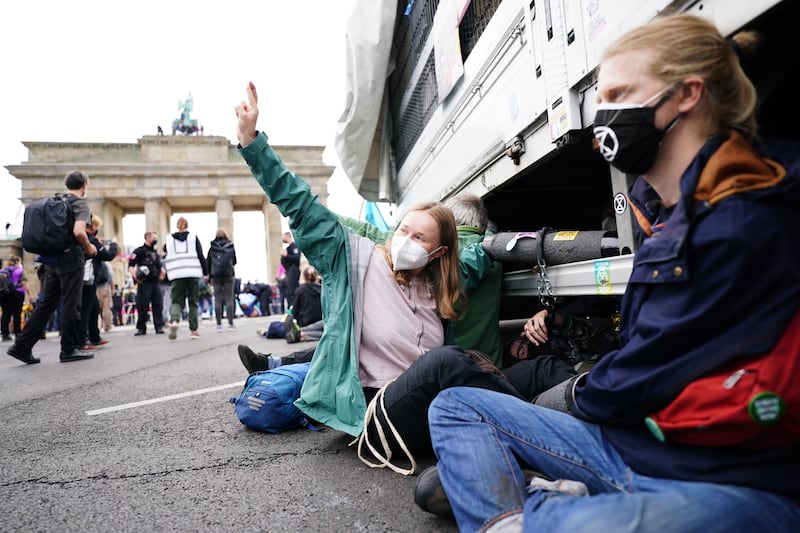 Activists are chained to a truck as they block the street in front of the Brandenburg Gate. EPA