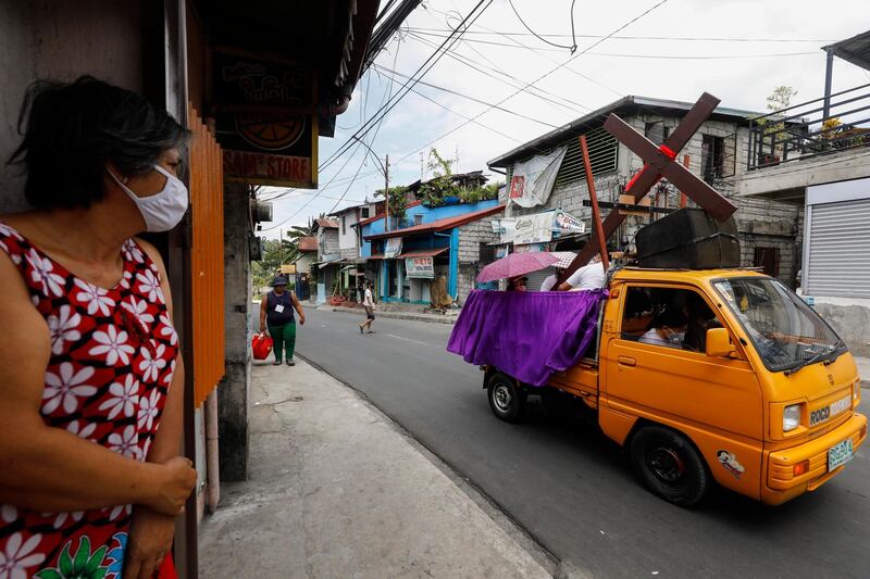 Catholic church staff riding a truck take a wooden cross around a quarantined community to mark Good Friday in Quezon City, Metro Manila, Philippines. EPA