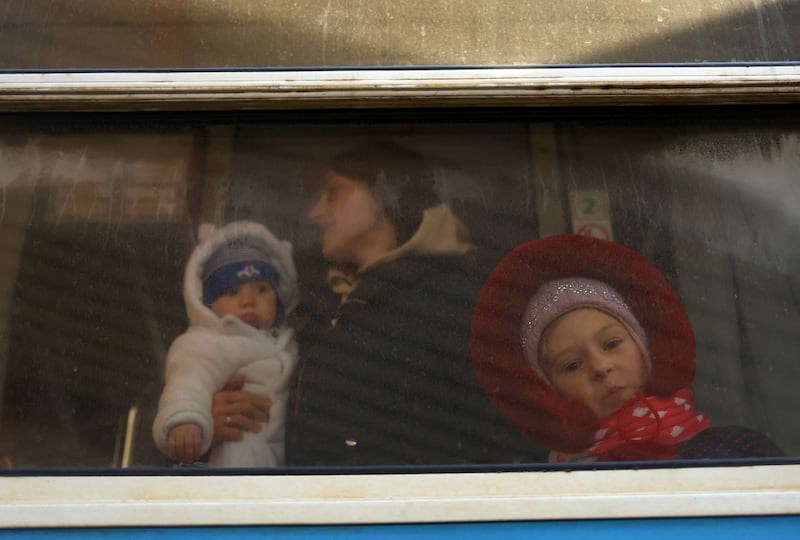 Ukrainian refugees look out of the window of a train bound for Krakow at Przemysl Glowny train station. Reuters