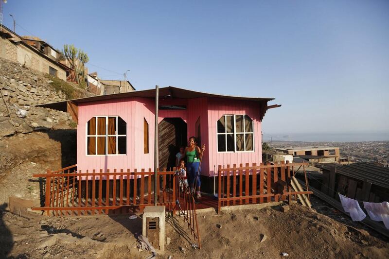 Sandra Neyra poses for a photo outside her house in Gosen City. Neyra and her husband, who works in construction, recently managed to save enough to paint their own home. Mariana Bazo / Reuters