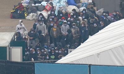Migrants wait to be processed after arriving in Dover. The UK government classes funding for hosting migrants as foreign aid. PA 
