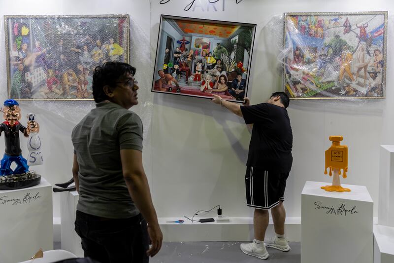 Sanuj Birla hangs some of his pieces of art. More than 4,000 artworks from 65 countries will be displayed across four days 