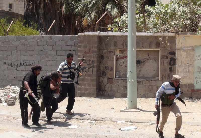 Fighters loyal to Yemen's president Abdrabu Mansur Hadi carry a comrade who sustained injuries during clashes with Houthi fighters in Aden on April 19.